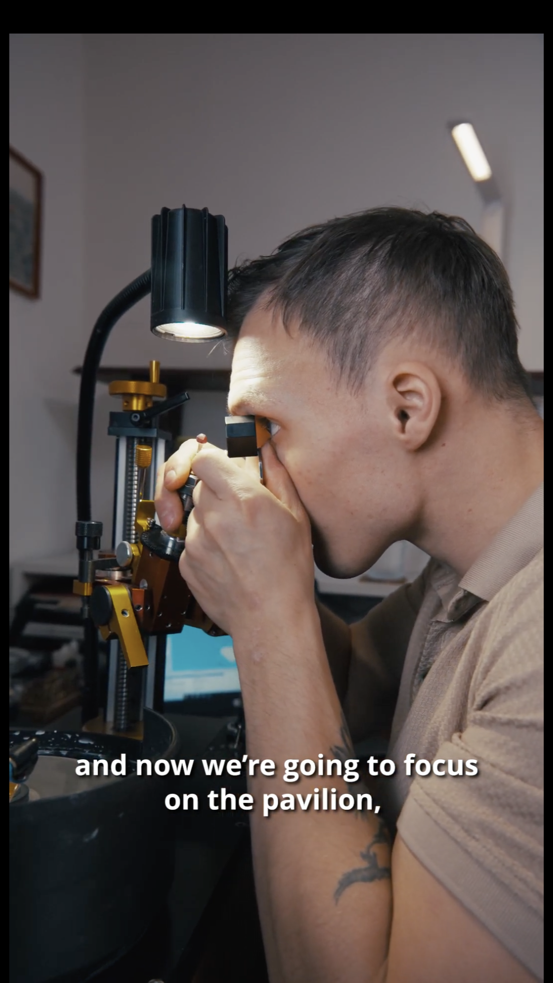 Gem cutter inspecting a stone under the microscope, focusing on the pavilion